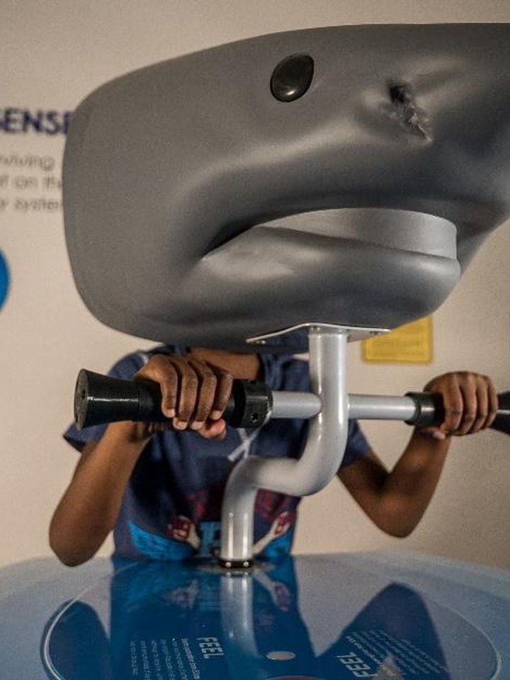 Child wearing shark VR headset at exhibit